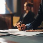 A Mesa personal injury lawyer reviewing paperwork at a desk.